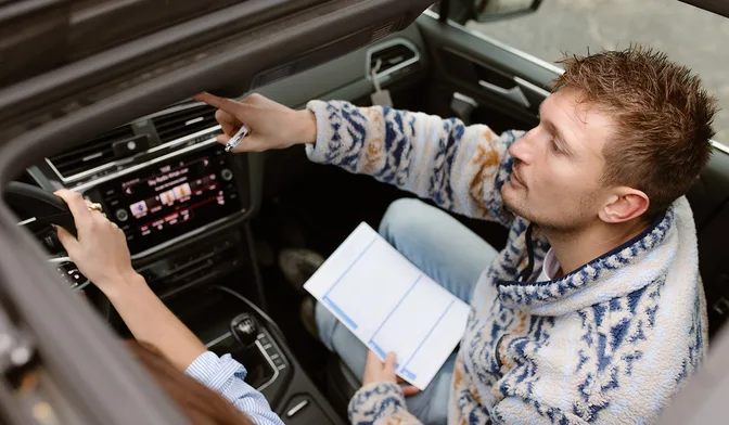 Instructeur wijst iets aan op het dashboard tijdens de les
