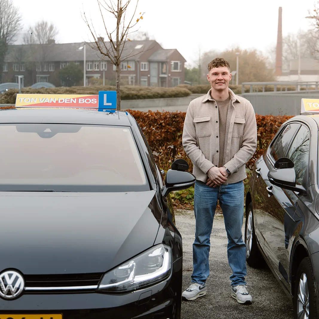 Geslaagde leerling naast de lesauto van Rijschool Ton van den Bos
