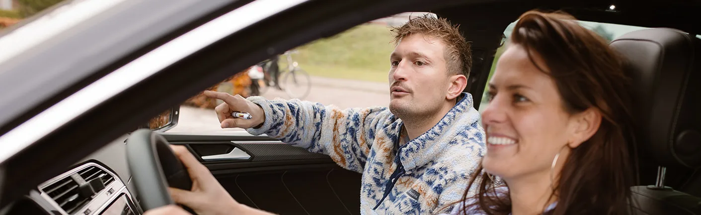 Instructeur wijst de weg tijdens een rijles