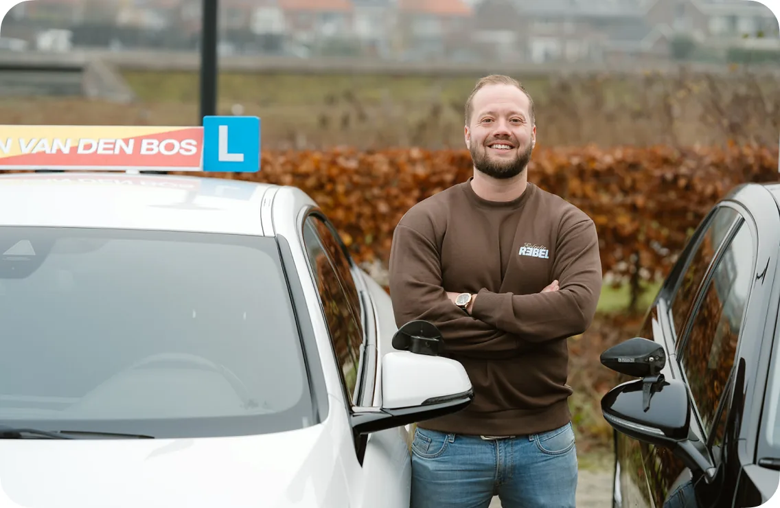 Instructeur van Rijschool Ton van den Bos naast een lesauto